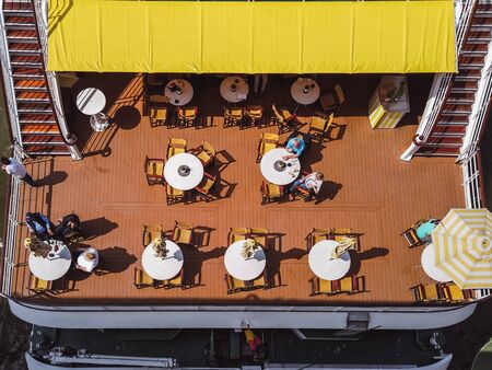Top view to cruise ship on Danube river in Budapest. Top view to people is sitting at the table,...