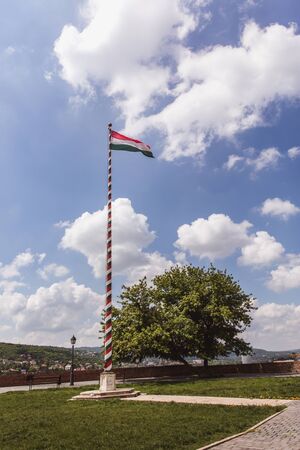 Hungarian flag on flagpole on blue skyの写真素材