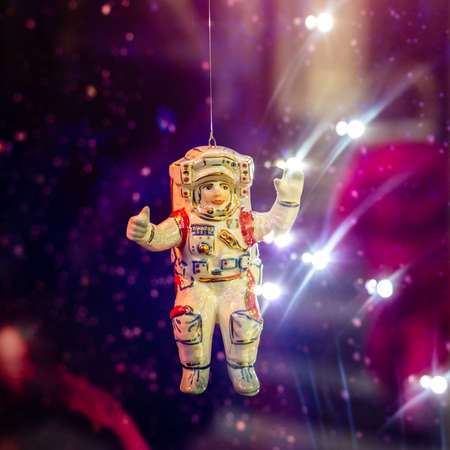 Christmas toy cosmonaut on the Christmas tree in neon lightの写真素材
