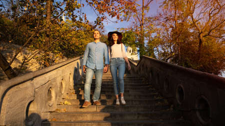 A beautiful young tourist couple are walking down stairs and looking around the castle of Buda in...