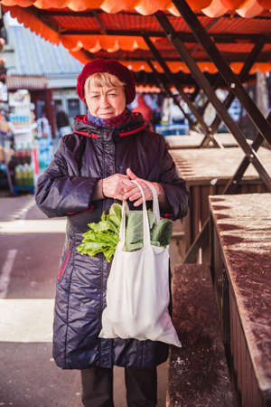Fresh leaves in organic bag in elderly woman hand, healthy lifestyleの写真素材