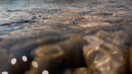 Pebbles stone underwater below water surface near lake shore, natural sceneの写真素材