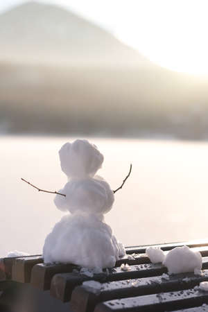Small snowman on sunlight in winter day on the beachの写真素材