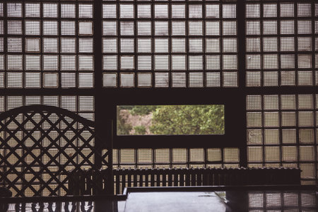 A window with multi-colored glass that overlooks a park or garden. Outside the window you can see a beautiful landscape. Old wooden window with shuttersの写真素材