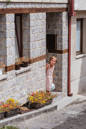Little girl walks along a cobbled street in the old town of Ohrid, Republic of North Macedoniaの写真素材