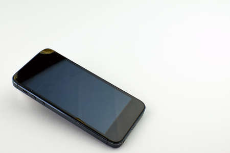 Phone with cracks and scratches on the display. Broken smartphone screen on a white backgroundの写真素材
