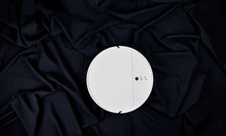 Robot vacuum cleaner on a black background. Modern robot vacuum cleaner, top view