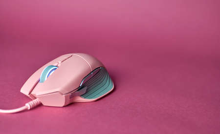 Modern gaming mouse. Pink gaming mouse. The concept of women's esports.の写真素材