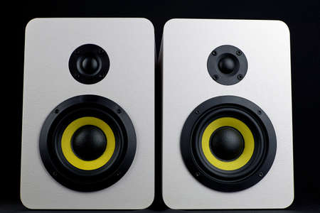 White audio speakers on a black background. Minimalistic audio speakers with yellow subwooferの写真素材