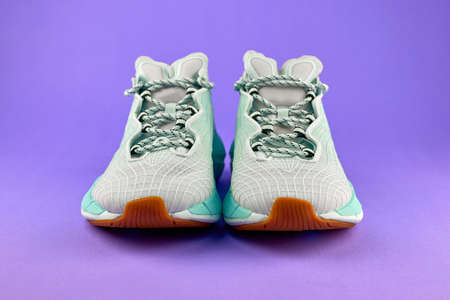 Modern running shoes. Pair of blue sports sneakers. The concept of fitness and running. Sports shoes on a purple backgroundの写真素材