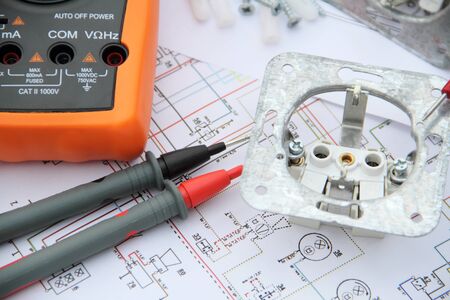 Sockets with a screwdriver and a measuring device on a circuit diagram