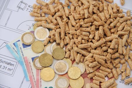 Wood pellets with money on a floor plan