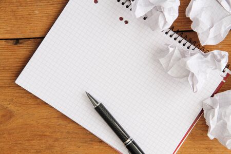 Empty writing pad with pen on a wooden tableの写真素材