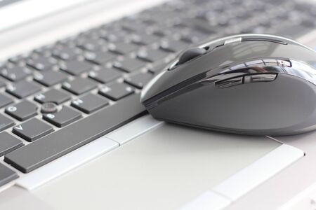 A laptop keyboard with a mouse