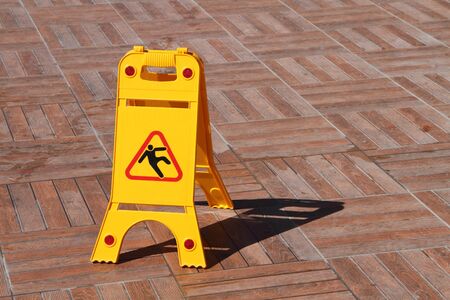 A yellow sign beware of danger of slipping