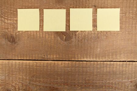 Four yellow notes on a wooden table