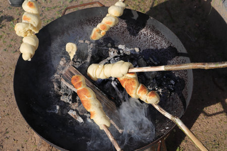 Making stick bread around the campfireの写真素材