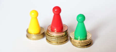 Three playing figures stand on euro coins as a concept in places 1, 2 and 3