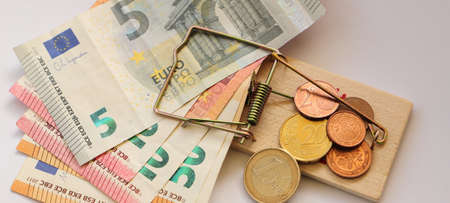 a wooden mousetrap with banknotes