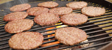 Burgers are grilled on a barbecue in the garden