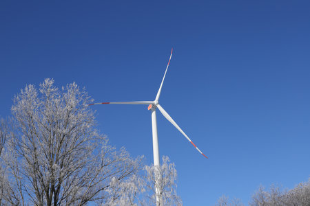Wind turbine on a field with blue sky