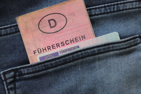 an old and a new German driving license with the inscription "FÃ¼hrerschein" in a trouser pocketの写真素材
