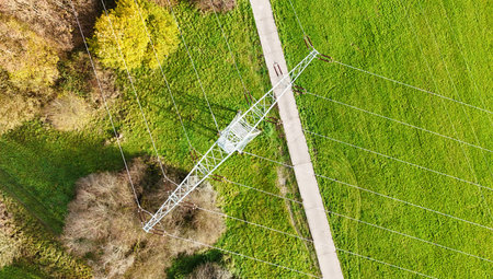 Aerial View of High Voltage Power Line Tower in Green Landscapeの写真素材
