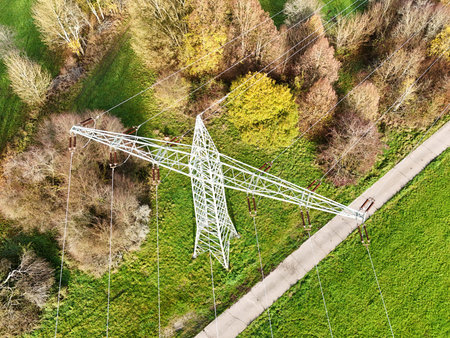 Aerial View of High Voltage Power Line Tower in Green Landscapeの写真素材