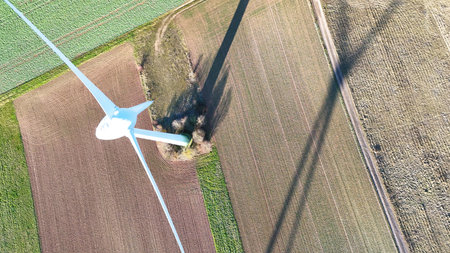 Aerial Wind Turbine Casting Shadow Across Agricultural Fields