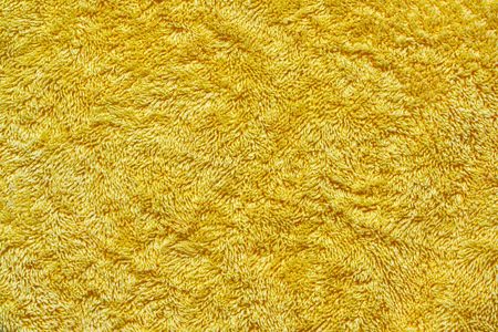 A closeup of a yellow gold towel, The texture and detail of the towel fills the entire frame.の写真素材