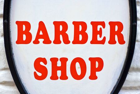 A Barber Shop sign with red letters and a white backgroundの写真素材