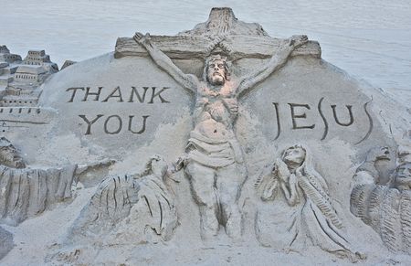 A sand sculpture on a beach of the crucifixion of Jesusの写真素材