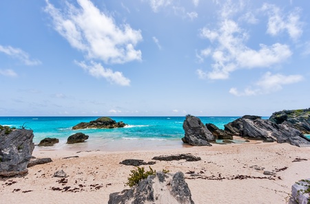 Horseshoe Bay in Bermuda  Sand and boulders are in the foreground in front of the blue water  It is...