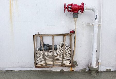 A coiled Fire Hose on a wallの写真素材