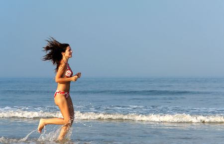 Beautiful girl running on the beachの写真素材