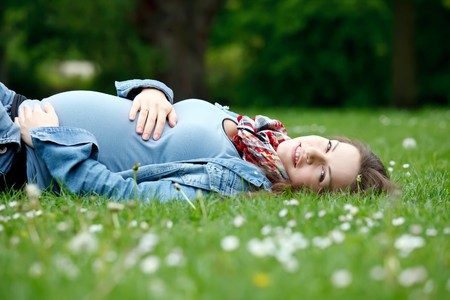Beautiful pregnant woman relaxing in the parkの写真素材