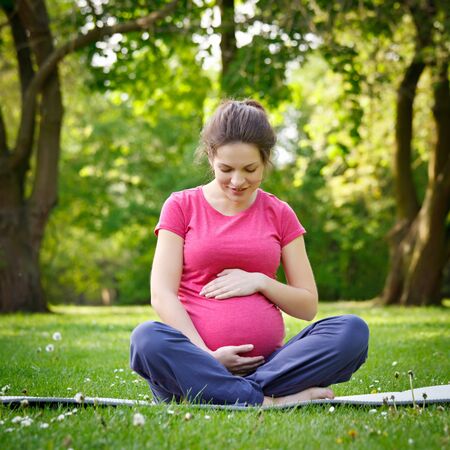 Beautiful pregnant woman relaxing in the parkの写真素材