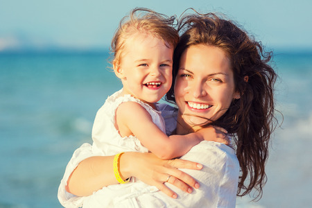 Portrait of mother and little daughter on the beachの写真素材