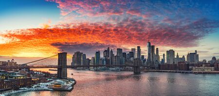 Panoramic view on Brooklyn bridge and Manhattan at vibrant sunset, New York Cityの写真素材