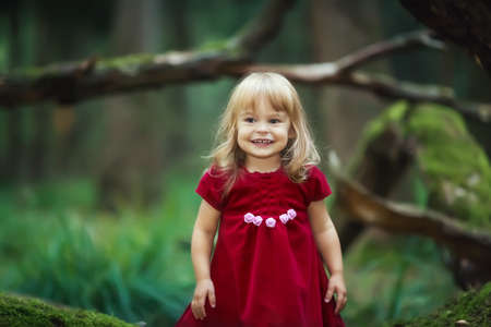 Little girl in the wild green forest