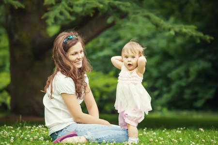 Mother and little daughter playing in the parkの写真素材