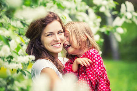 Portrait of happy mother and little daughter in spring parkの写真素材