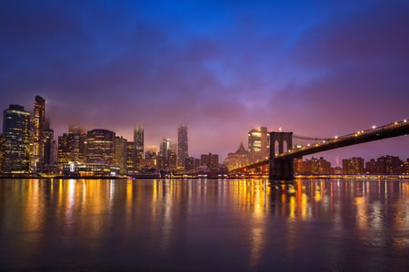 Panoramic view on Manhattan and Brooklyn bridge at night, New York Cityの写真素材