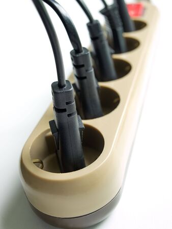 Close up of power plugs into the outlet on a clear background.