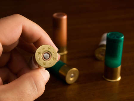 Hunter shows the caliber of  hunting cartridges.の写真素材