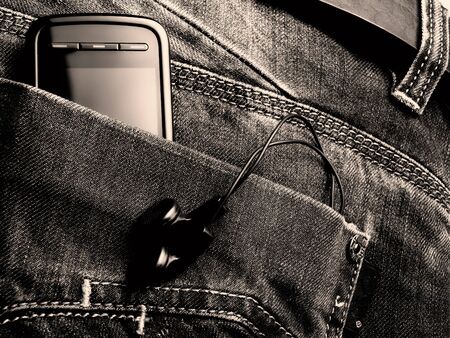 Metaphor about new jeans generation with digital equipment. Toned BW image.の写真素材