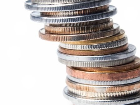 Macro of various coins on a white background.