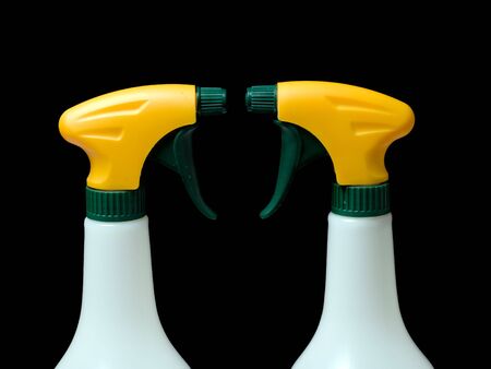 Two spray bottles isolated on a black background