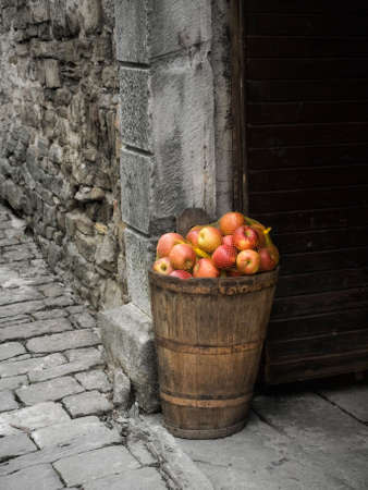 Ripe apple in the basket by the door on a stone street ...の写真素材