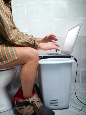 Conceptual view of  an internet addict during "calling of nature"  in the toilet.の写真素材